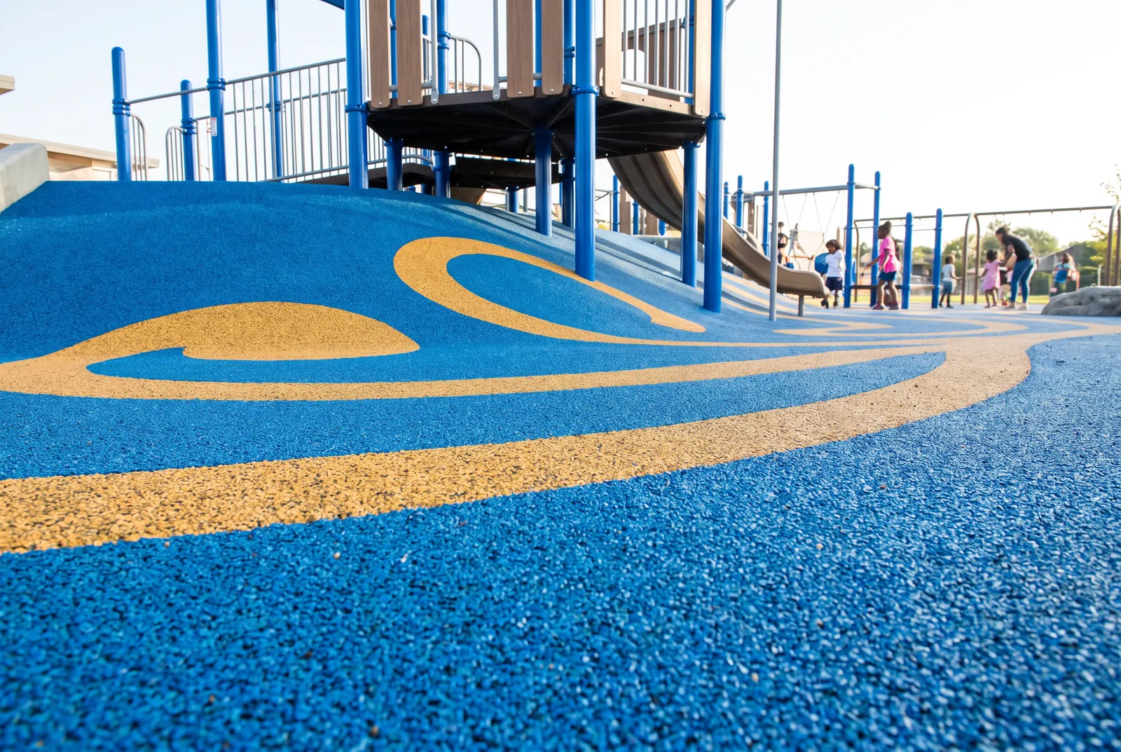 Close view of blue and gold poured-in-place rubber surfacing with its rubber granules visible